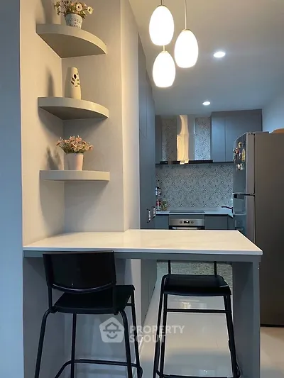 Modern kitchen with sleek design, featuring open layout and stylish lighting, perfect for contemporary living.