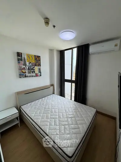Modern bedroom with large window and air conditioning in a stylish apartment.