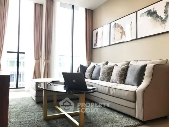 Elegant living room with modern sofa, stylish decor, and large windows for natural light.