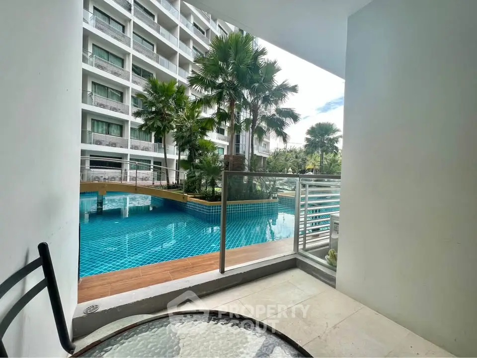 Luxurious poolside balcony view in modern apartment complex with palm trees