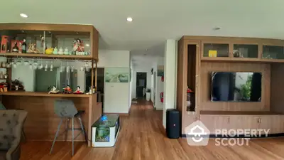 Spacious living room with modern wooden cabinetry and bar area