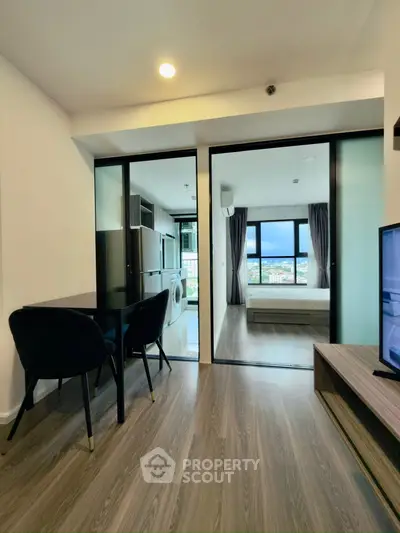 Modern apartment interior with open layout, featuring a cozy living area and a bedroom with a stunning view.