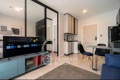 Modern living room with sleek furniture and open kitchen layout in a stylish apartment.