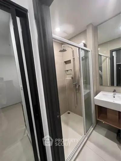 Modern bathroom with glass shower enclosure and sleek sink design
