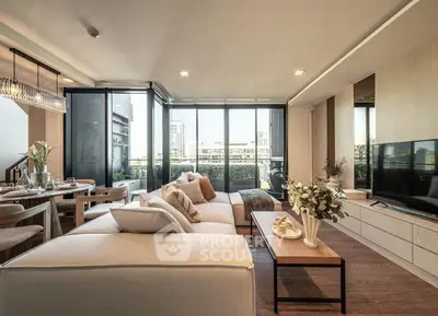 Luxurious open-plan living space with elegant furnishings, leading to a sunlit balcony with urban views, perfect for upscale city living.