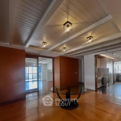 Spacious modern living room with elegant ceiling lights and open kitchen layout