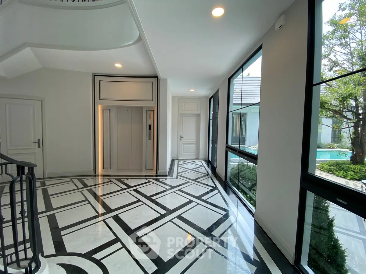 Luxurious modern entrance with elegant elevator and stunning garden view.