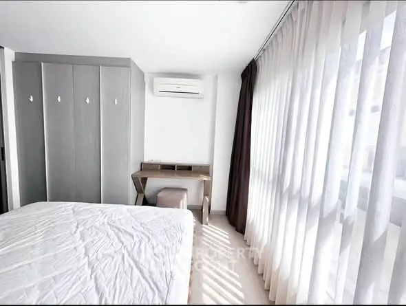 Bright modern bedroom with large windows and sleek furniture