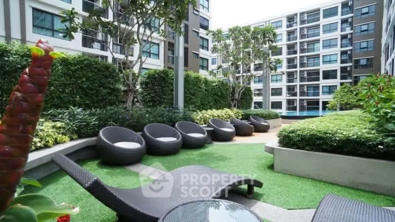 Modern apartment complex with lush garden and stylish outdoor seating area.