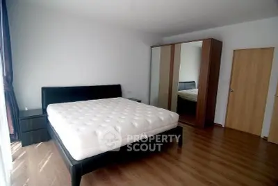 Spacious bedroom with modern furniture and wooden flooring