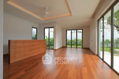 Spacious modern living room with wooden flooring and garden view