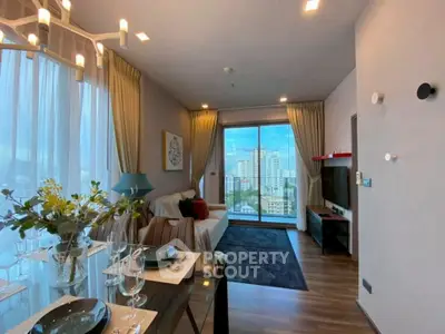 Modern living room with city view, elegant decor, and large windows in a high-rise apartment.