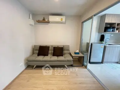 Modern living room with cozy sofa and adjacent kitchen area