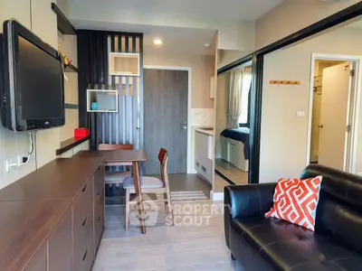 Modern living room with sleek furniture and wall-mounted TV in cozy apartment.
