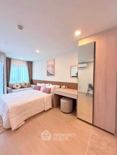 Modern bedroom with stylish decor and ample natural light, featuring a cozy bed and sleek wardrobe.