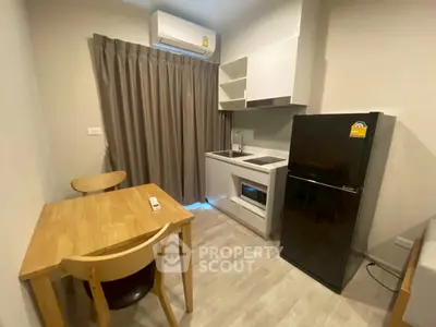 Cozy kitchen with modern appliances and dining area in compact apartment.