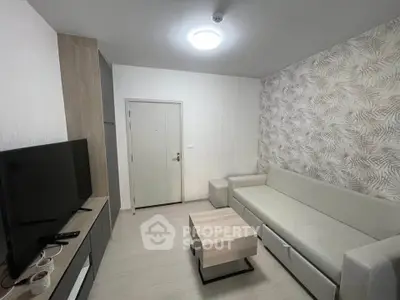 Modern living room with stylish decor and neutral tones, featuring a sleek TV setup and comfortable seating.