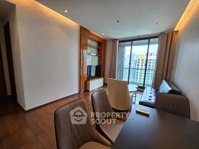 Modern living room with large windows and stylish furniture in a high-rise apartment.