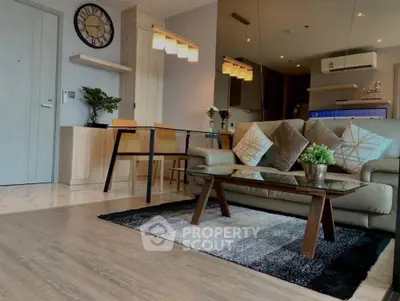 Modern living room with stylish decor, glass coffee table, and cozy seating in a contemporary apartment.