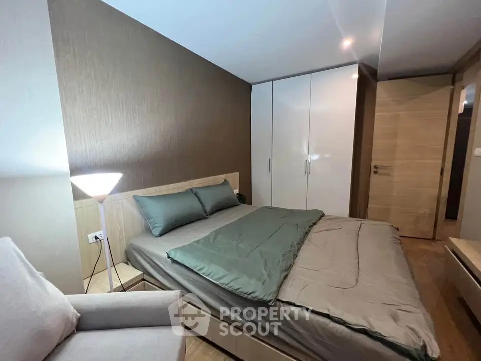 Cozy bedroom with modern decor and ample storage in a stylish apartment.