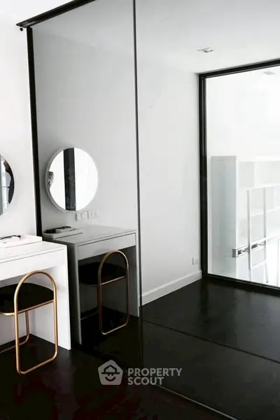 Modern minimalist study area with sleek black flooring and mirrored wall