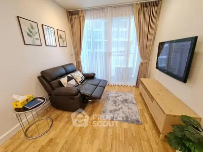 Modern living room with sleek leather sofa and wall-mounted TV, featuring elegant decor and natural light.