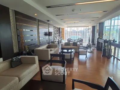 Spacious and elegant living room with modern furniture and large windows offering natural light.