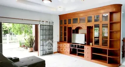 Spacious living room with elegant wooden cabinetry and garden view, perfect for relaxation and entertainment.