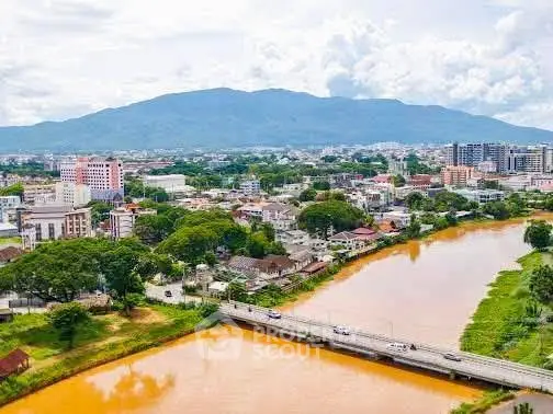 Scenic aerial view of a vibrant cityscape with river and mountain backdrop, ideal for urban living.