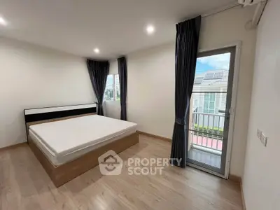 Spacious bedroom with large windows and balcony access in modern home