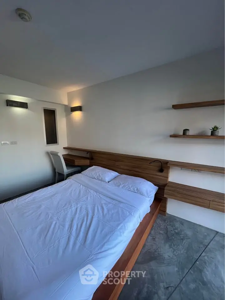 Modern minimalist bedroom with sleek wooden furniture and ambient lighting