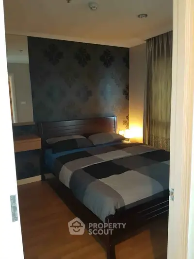 Cozy bedroom with elegant wallpaper and warm lighting, perfect for relaxation.