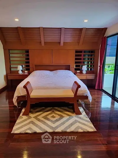 Luxurious bedroom with wooden accents and large windows for natural light.