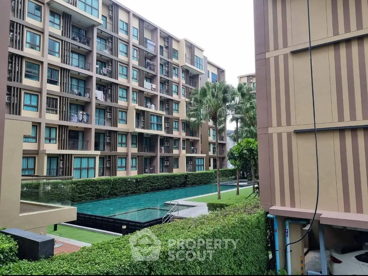Modern apartment complex with pool and lush greenery, offering a serene urban living experience.