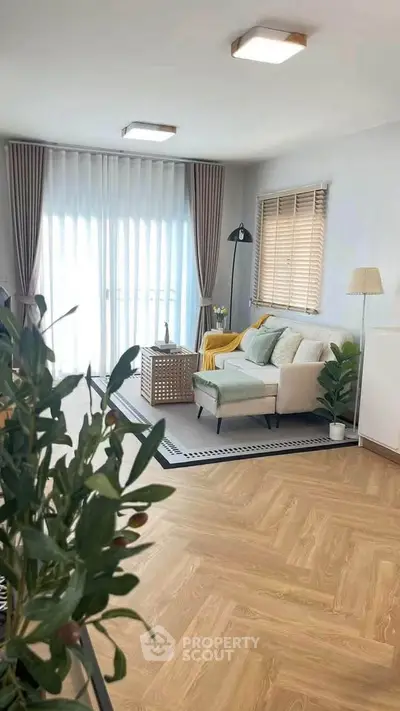 Bright and modern living room with stylish decor and large windows.