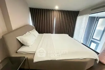 Modern bedroom with large windows and elegant curtains in a stylish apartment.
