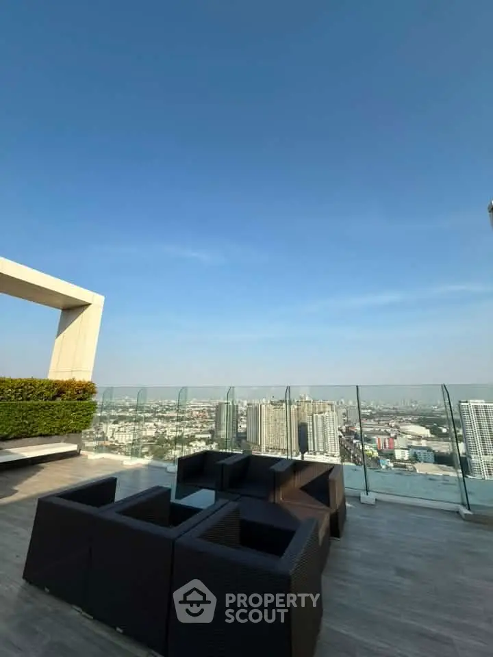 Stunning rooftop view with modern outdoor seating and panoramic cityscape.