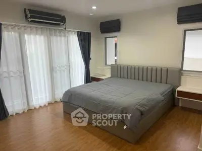 Spacious bedroom with modern decor and large windows for natural light