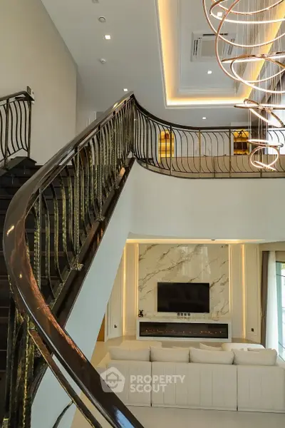 Luxurious living room with elegant staircase and modern lighting