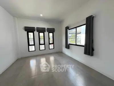 Spacious empty room with large windows and modern tile flooring, perfect for customization.