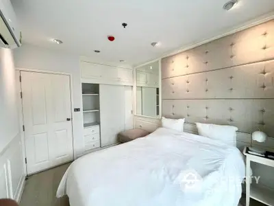 Modern bedroom with plush headboard and built-in storage in a bright apartment