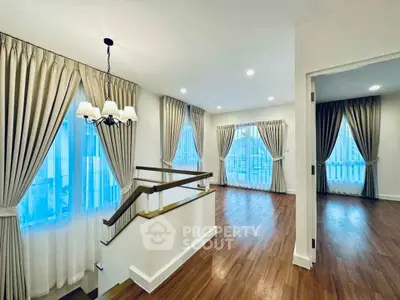 Spacious living area with elegant curtains and wooden flooring