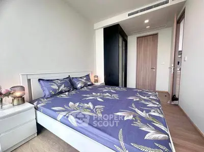 Modern bedroom with floral bedding and sleek design in a contemporary apartment.