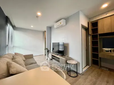 Modern living room with sleek design and air conditioning, featuring a cozy sofa and entertainment unit.
