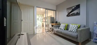 Modern living room with sleek gray sofa and open kitchen layout, perfect for urban living.