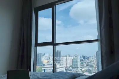 Stunning cityscape view from a modern high-rise bedroom window, offering a serene urban living experience.