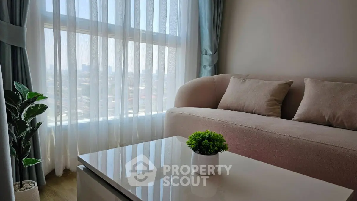Stylish living room with plush sofa and city view through sheer curtains, perfect for modern urban living.