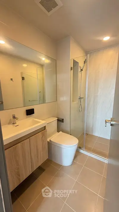 Modern bathroom with sleek design, glass shower, and wooden vanity in a contemporary home.