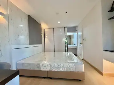 Modern bedroom with sleek design and ample natural light, featuring a comfortable bed and stylish decor.