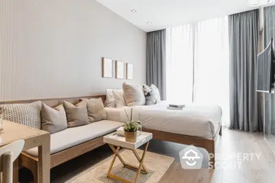 Modern bedroom with cozy seating area and natural light